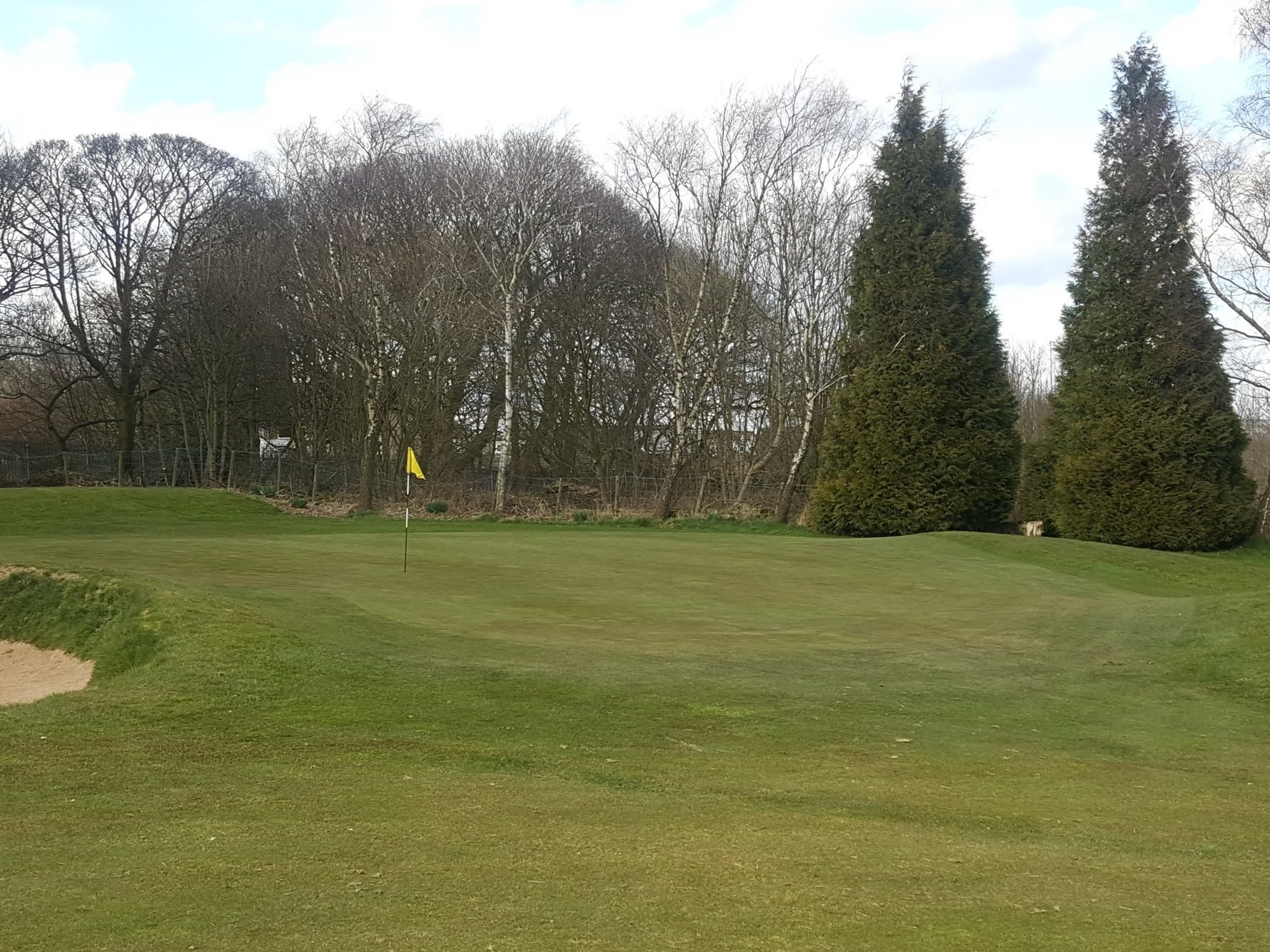 The contoured, sloping 1st Green.